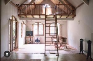 a room with a loft bed with a ladder at HOMESTAY ARGOPENI in Kalianget