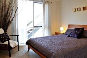 a bedroom with a bed and a window and a chair at Marians in Aireys Inlet