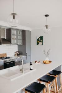 a kitchen with a sink and a counter with stools at Lillet on Short I King Beds I Stay Dubbo in Dubbo