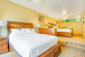 a bedroom with a large white bed and two beds at Hale Moi #103B in Princeville