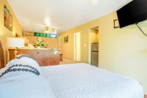 a bedroom with a white bed and a kitchen at Hale Moi #103B in Princeville