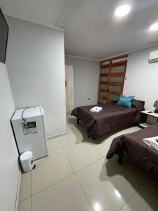a room with two beds and a refrigerator at Residencial Astorga in Rancagua +42 photos
