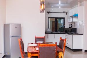 a kitchen with a table and chairs and a refrigerator at BlueGreens Accommodation in Ndola