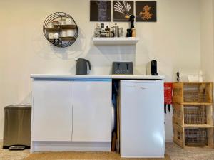 a kitchen with a white counter and a refrigerator at Private Papamoa Beach Paradise in Papamoa