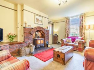 a living room with a brick fireplace and a couch at Wychwood in Whitby