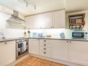a white kitchen with white cabinets and appliances at Wychwood in Whitby