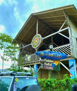 a car parked in front of a building with a sign at Hostal Camping Sin Fronteras Mompiche in Mompiche