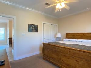 Schlafzimmer mit einem Holzbett und einem Deckenventilator in der Unterkunft Parrot Bay 37cu By Pkrm in Pensacola