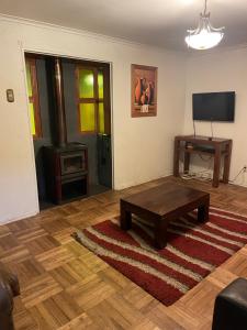 a living room with a coffee table and a television at Manso de Velasco in Rancagua