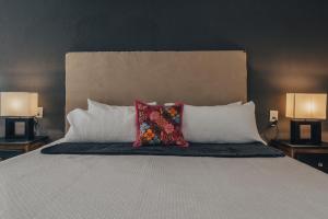 a bed with two pillows on it with two lamps at Hotel Casa Santamaría in San Miguel de Allende