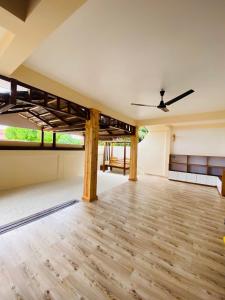 an empty room with a ceiling fan and wooden floors at Stay Salty in Gaafaru