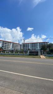 a large white building on the side of a road at Seaview Beachfront Maephim Beach A12 A13 in Rayong