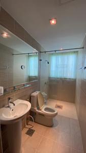 a bathroom with a toilet and a sink and a mirror at Seaview Beachfront Maephim Beach A12 A13 in Rayong