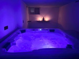 Habitación púrpura con bañera grande en una habitación en Villa Rossa Gozo - 5 bedroom ensuite with pool & jacuzzi, en Xewkija