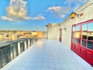 een rode deur aan de zijkant van een gebouw bij Villa Rossa Gozo - 5 bedroom ensuite with pool & jacuzzi in Xewkija