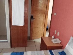 a bedroom with a door and a phone on a table at Hotel Malinalli Bella Vista in Puebla