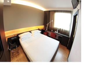 1 dormitorio con 1 cama blanca grande y escritorio en Postumia Hotel Design, en Oderzo