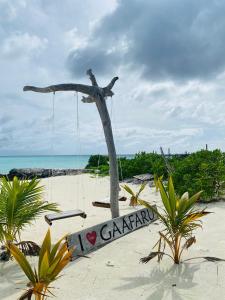 un columpio en una playa con las palabras caravana en Stay Salty, en Gaafaru