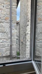 une fenêtre avec vue sur un mur de briques dans l'établissement Casa Vacanze: La casa di Gin, à Viterbe
