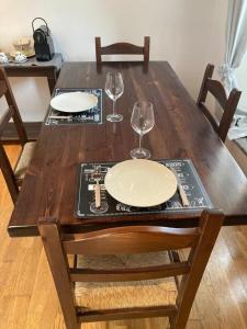 une table en bois avec deux assiettes vides et des verres à vin dans l'établissement Casa Vacanze: La casa di Gin, à Viterbe 3 autres photos