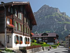 a building with flowers on the windows and a mountain at Chalet Spillstatt in Grindelwald