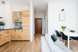 a living room with a couch and a table at Grey Rentyear Apartments in Gdańsk