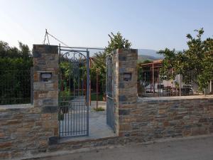 an entrance to a stone wall with a metal gate at PILIO PARADISE GARDEN in Koropi