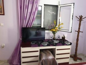 a room with a desk with a tv and a window at PILIO PARADISE GARDEN in Koropi