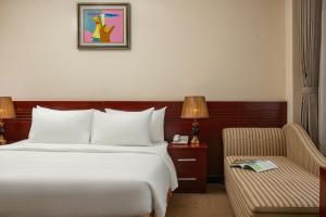 a hotel room with a bed and a chair at A25 Premium Hotel - 705 Lac Long Quan in Hanoi