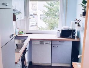 a kitchen with a counter with a microwave and a window at Apartment to stay in Wernau