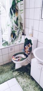 a bathroom with a toilet with a flower arrangement on it at Apartment to stay in Wernau