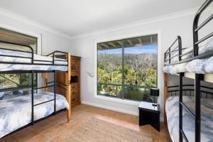 a bedroom with bunk beds and a window at Tumbaramba in Wye River