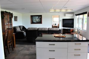 Serenity Views في روتوروا: غرفة معيشة مع أريكة وتلفزيون