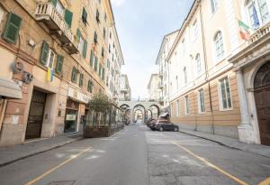 an empty city street with a car parked in the middle at Via Manzoni in Savona