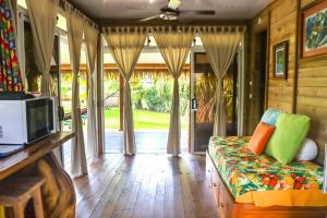 - un salon avec un canapé et une télévision dans l'établissement Bungalow Bali Hai, à Fare