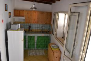 a small kitchen with wooden cabinets and a refrigerator at Pretty Damuso Style Villa in Lampedusa