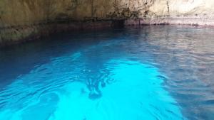 a person swimming in a pool of blue water at Pretty Damuso Style Villa in Lampedusa