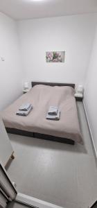 ein Bett in einem weißen Zimmer mit zwei Lampen in der Unterkunft ZAD Senj Apartman in Senj