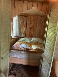 een slaapkamer met een bed in een houten hut bij Bungalow Biberspur in Zieko