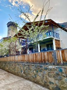 a house with a fence on a stone wall at GUEST HOUSE ,, MEMORY'' in Mestia