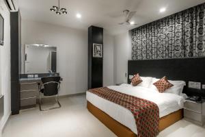 チェンナイにあるSaaral Residencyのベッドルーム(ベッド1台、シンク、鏡付)