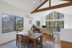 Un comedor con mesa y sillas y ventanas. en Morgans at Lorne, en Lorne