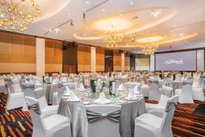 a conference room with tables and chairs and a screen at The Landmark Bangkok - SHA Extra Plus in Bangkok