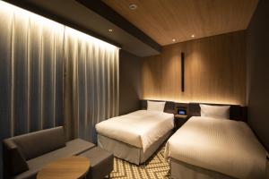 سرير أو أسرّة في غرفة في Hotel Keihan Tenmabashi Ekimae