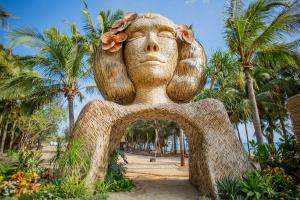 een beeld van een aap met bloemen op zijn hoofd bij Hola Beach - Beach Club & Eco Glamping Resort in Ke Ga