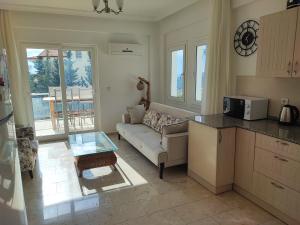 een keuken en een woonkamer met een bank en een tafel bij Villa Holly in Fethiye
