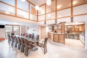 a kitchen and dining room with a table and chairs at Rezidence Club Canada Appartement XXL conference rooms sauna gril in Lipno nad Vltavou