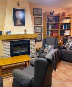 a living room with two chairs and a fireplace at Casa Neferet in Candeleda
