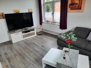 a living room with a flat screen tv and a couch at Stefanie in Heide