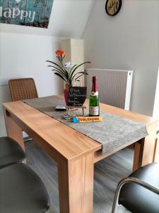 a dining room table with a bottle of wine on it at Ferienhaus Joschko in Bad Arolsen